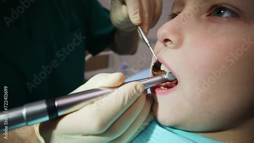 Dentist have teeth attended of boy by mirror and dental drill at hospital photo