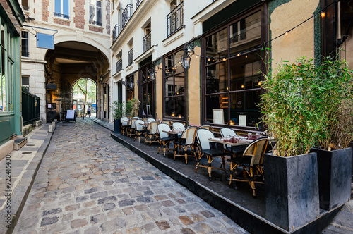 Cozy street near Boulevard San-German with tables of cafe in Paris, France. Architecture and landmark of Paris. Paris cityscape