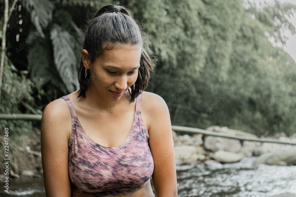 Retrato de una mujer joven vestida con ropa deportiva mientras pasea por el río 