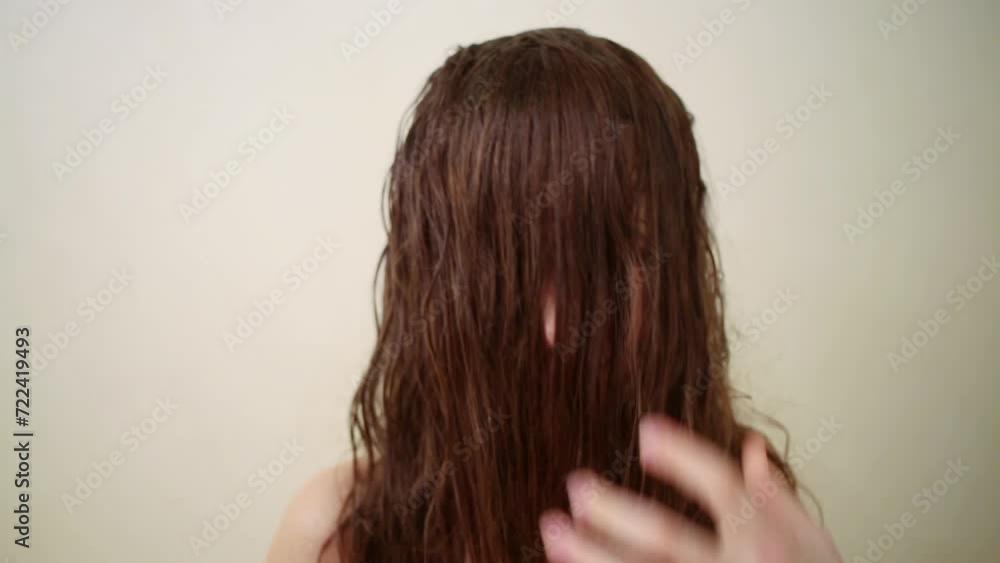 Little girl with a long wet brunette hair is standing alone near wall. Little girl with a long wet brunette hair is standing alone near wall.
