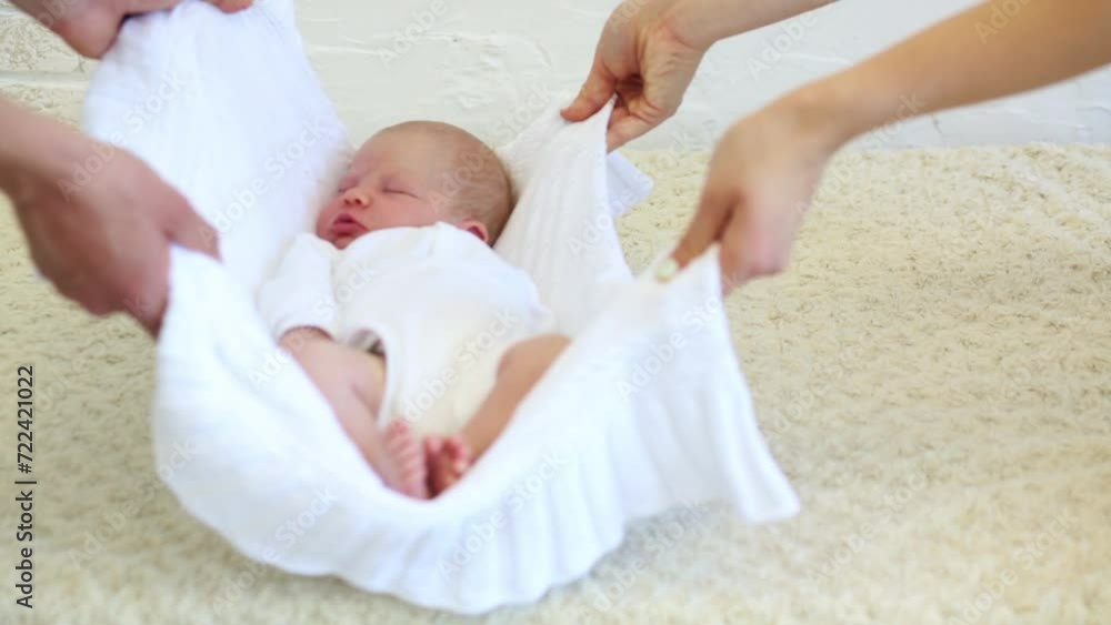 Two parents are lifting newborn baby with white blanket. Two parents are lifting newborn baby with white blanket.