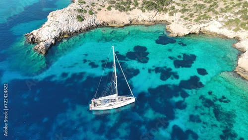 Aerial drone cinematic video of sail boat anchored in tropical paradise exotic island bay with emerald crystal clear waters in Caribbean destination photo