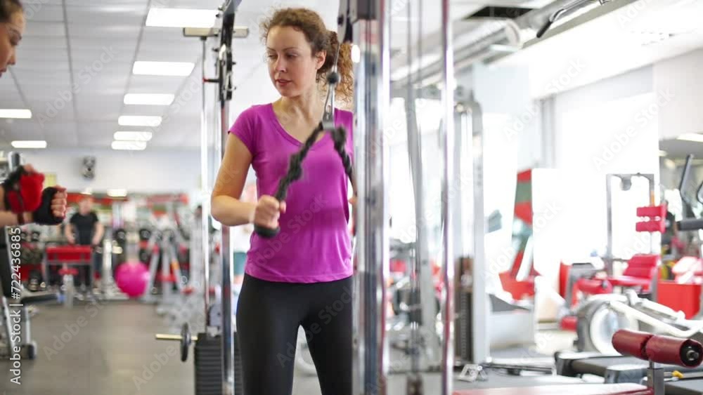 Trainer is showing how use sport equipment to curly woman. Trainer is showing how use sport equipment to curly woman.