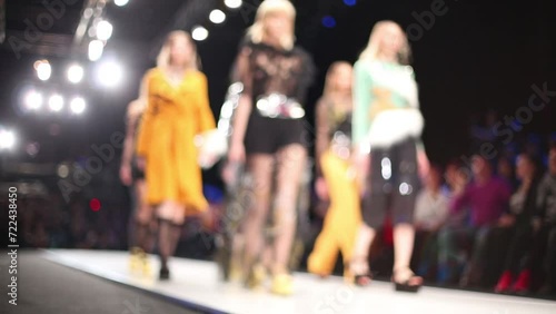 Models are walking on the podium under spotlights in designers clothes photo
