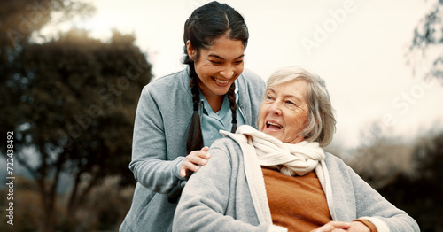 Senior woman, talking and outdoor with caregiver, nurse or healthcare service for person with a disability and wheelchair. Happy, face and elderly lady in park with care and support in retirement