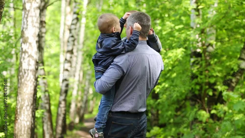 Father hold two sons, touching his nose and turn with them on path Father hold two sons, touching his nose and turn with them on path