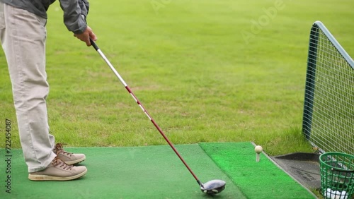 Man is putting golf ball and swinging the cammock for hit it. photo