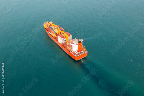 Aerial view of cargo container ship carrying containers for import and export, business logistic and transportation in open sea. Top downn drone view. Freight shipping