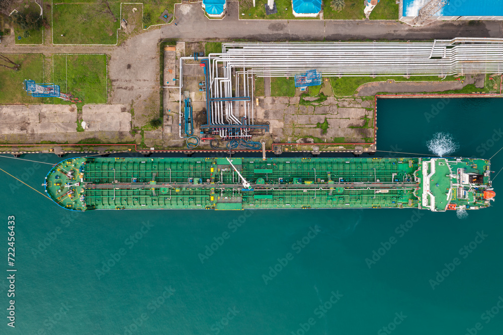 Aerial top down view oil ship tanker vessel loading in gas and oil terminal station refinery, Global trading import export logistic transport sea freight cargo tanker at port