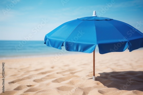 A blue umbrella sitting on top of a sandy beach. Perfect for beach vacations and summer getaways © Fotograf