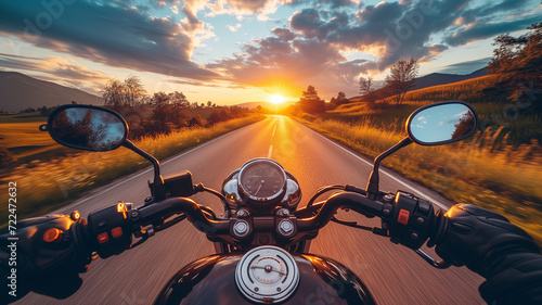 A motorcycle speeds on a road at sunset, motorcyclist's point of view