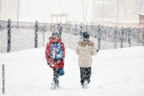 Wallpaper Mural Two friends overcoming a winter snowstorm as they walk through the snow, in a snowfall Torontodigital.ca