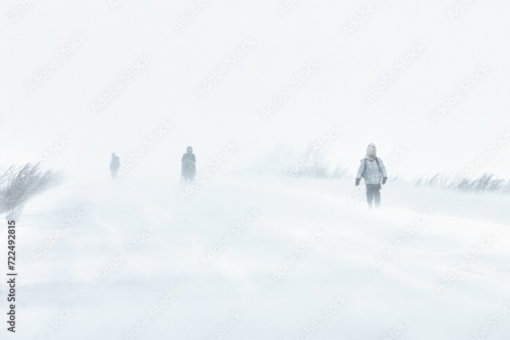 A snowstorm in the city. People are walking down the street during a snowstorm. Strong wind and snowfall. Arctic climate..