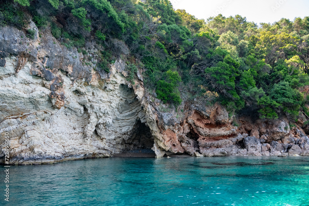 Scenic landscape of Island of Corfu, Greece, western shoreline with cliffs and caves at beach and water line of turquoise or deep blue water with breath taking limestone formations