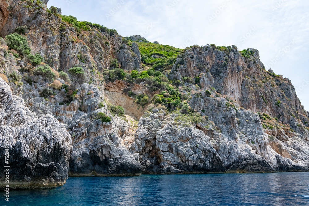 Scenic landscape of Island of Corfu, Greece, western shoreline with cliffs and caves at beach and water line of turquoise or deep blue water with breath taking limestone formations