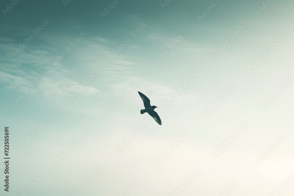 Fototapeta premium Gracefully soaring amidst the billowing clouds, an aquatic bird embarks on its journey of migration, its outstretched wings carrying it through the vast expanse of the open sky