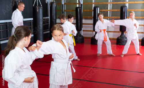 Karate kids in kimono sparring together during their group karate training.