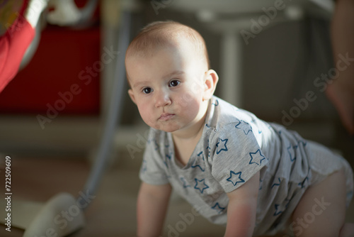 A baby is a happy baby in the first months of life, crawling around the house, smiling.