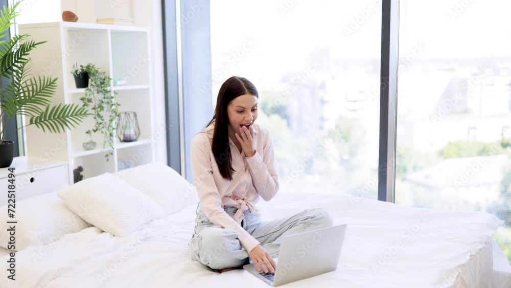 Happy young woman in casual wear raising hands up while using laptop for ordering new cosmetics during sale season. Online shopping with discount at home. E-commerce and technology concept. Happy young woman in casual wear raising hands up while using laptop for ordering new cosmetics during sale season. Online shopping with discount at home. E-commerce and technology concept.