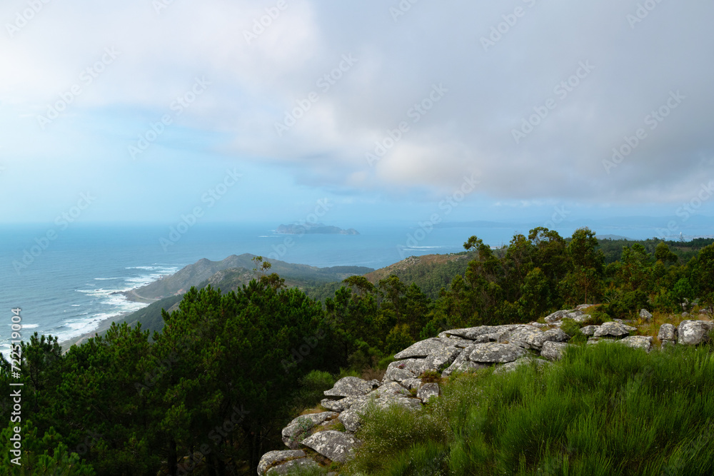 Panoramic view from the mountain of the coast of Baiona and Cabo Silleiro with the Cies Islands in the background on a cloudy day. Baiona - Spain