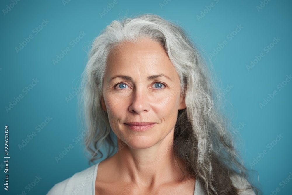 Portrait of a beautiful senior woman with grey hair on blue background Portrait of a beautiful senior woman with grey hair on blue background