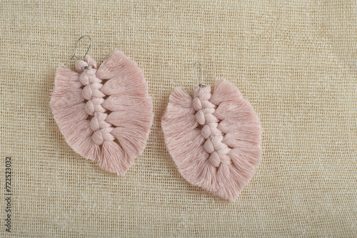 Earrings made with thread on a textile background. Handmade earrings.
