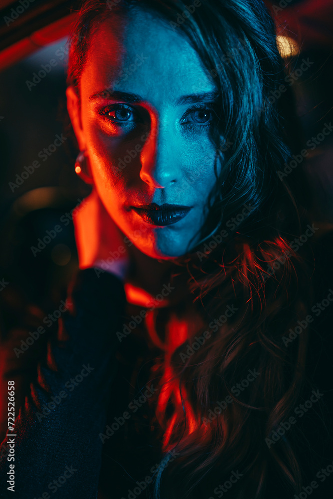 Chica joven posando con luces rojas y azules de noche Chica joven posando con luces rojas y azules de noche