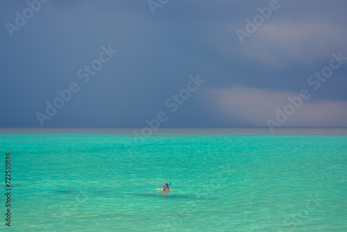 A person snorkelling in Caribbean sea during rain. Beautiful tropical colours. 