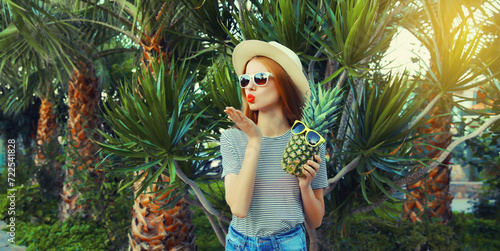 Summer portrait of beautiful young woman with pineapple fruits posing