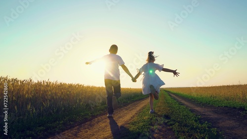 Children play fun run holding hands. Child, nature vacation. Childhood dream concept, Carefree child in summer. Children in together run through wheat field at sunset. Happy family. Boy girl playing
