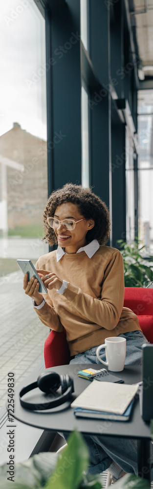 Smiling woman executive manager is using mobile phone sitting in office during break time Smiling woman executive manager is using mobile phone sitting in office during break time