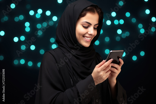 Woman wearing black hijab looking at her smart phone. Perfect for depicting modern technology and communication in diverse cultures