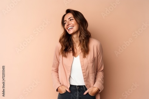 Portrait of a beautiful young woman on a pink background laughing.