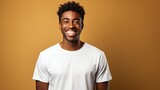  Studio shot of cheerful beautiful African man in white t - shirt and stand smiling with braces on yellow background. 