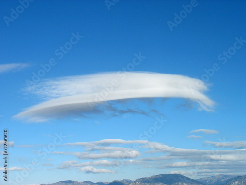 Lenticular cloud over San Gabriel Mountains of Los Angeles County, California. Strawberry Peak trail. Beautiful sky and range landscape panorama with white clouds in blue sky.