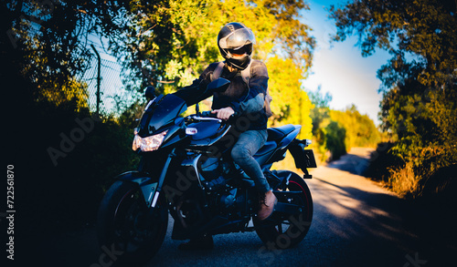 Fototapeta Naklejka Na Ścianę i Meble -  Men riding a black sport motorcycle