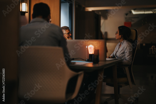 A focused group of multigenerational professionals in a business meeting, showcasing teamwork and collaboration in a modern office environment.