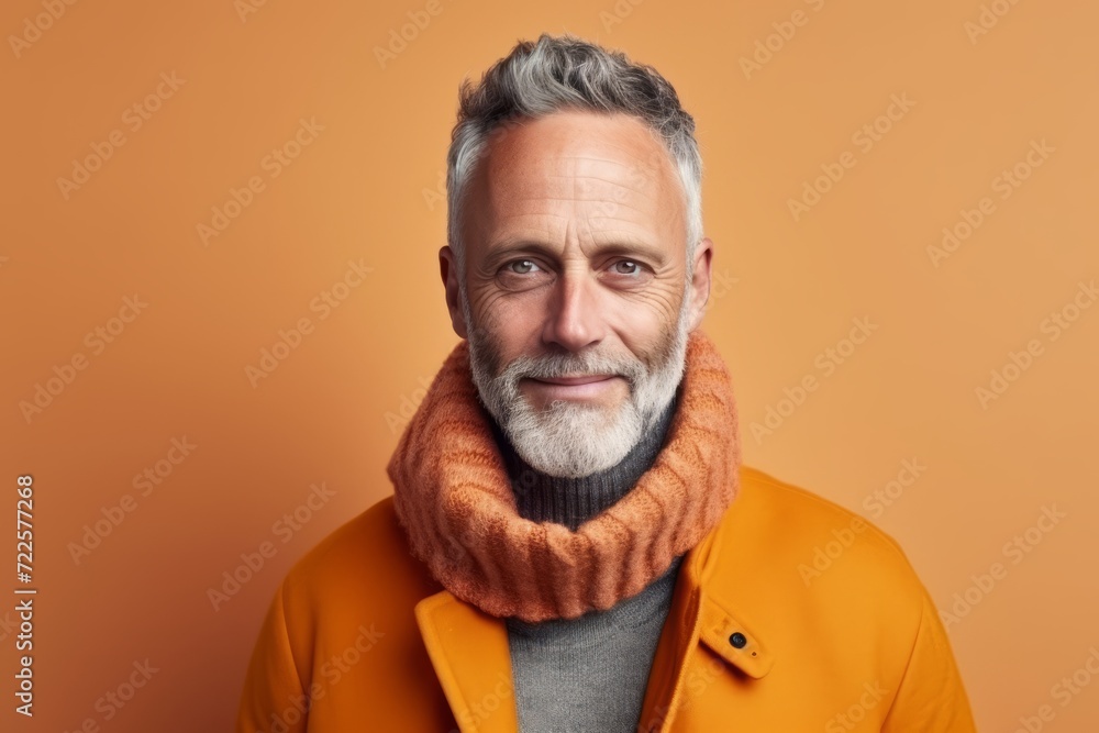 Portrait of a handsome senior man wearing a warm orange coat and scarf. Portrait of a handsome senior man wearing a warm orange coat and scarf.
