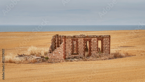 Ruins of an old, brick farmhouse on a cliff in a freshly harvested field - Yorke Peninsula, South Australia