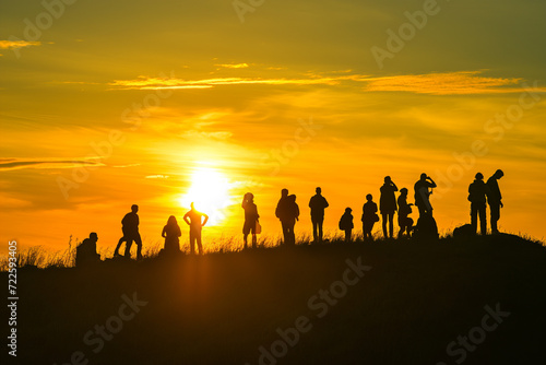 Group of People Standing Atop a Hill  Enjoying the View