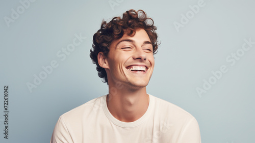 Happy smiling young adult man on a solid background