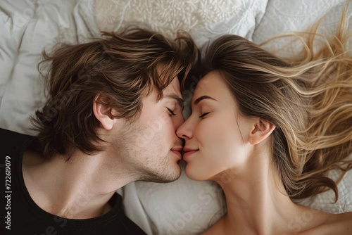 A passionate embrace between two lovers on a bed, their skin touching as they share a tender kiss, the human faces expressing deep love and desire for each other photo