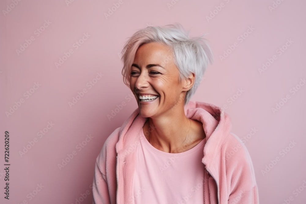 Portrait of a happy senior woman smiling against a pink background. Portrait of a happy senior woman smiling against a pink background.