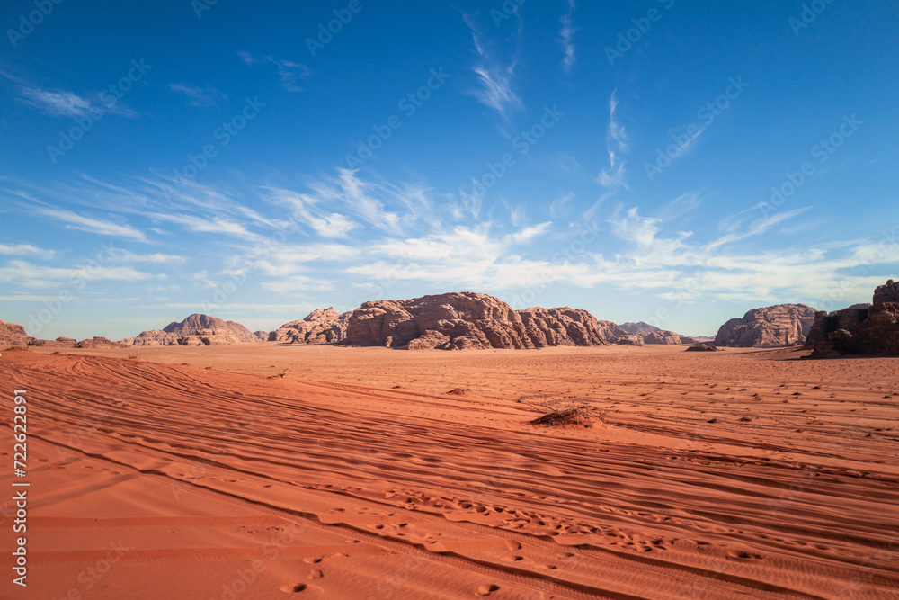 Naklejka premium Wadi Rum, Jordan, Scenic view of Arabic Middle Eastern desert against clear blue sky with sand tracks in foreground. Mountain in background. Copy space no people