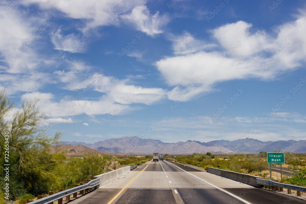 Beautiful blue sky with fluffy clouds over the highway. Scenic road in Arizona, USA on a sunny summer day. 40 hwy, 10 hwy in Arizona, USA - 17 April 2020