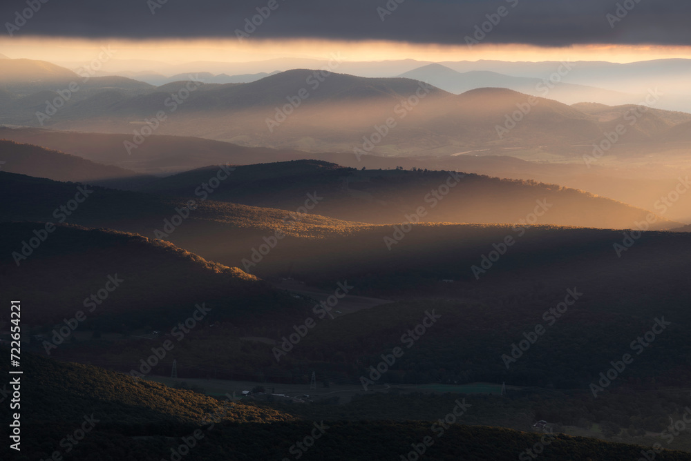 Rays of light fill the valleys of West Virginia during an overcast Autumn sunrise in the Appalachian Mountains. Rays of light fill the valleys of West Virginia during an overcast Autumn sunrise in the Appalachian Mountains.