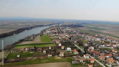 Drone captures small houses in village Jarkovci in plain countryside near lake photo