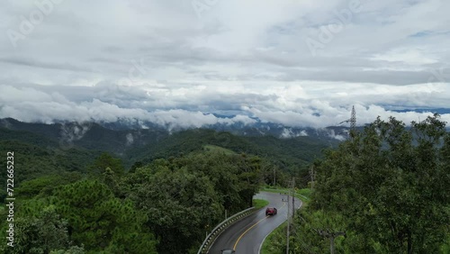 Mae hong son, Thailand. Fog-Kissed Drive: Tranquil Aerial Views of Two Cars Winding Through the Misty Landscape After Rain. 
