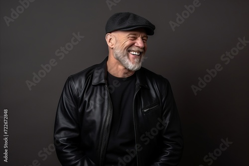 Portrait of a happy senior man in leather jacket and cap.