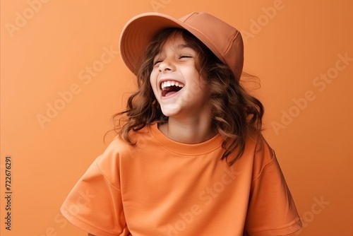 Portrait of a cute little girl in orange t-shirt and hat